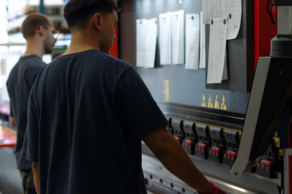 Two engineers collaborating on a machine in an industrial production workshop