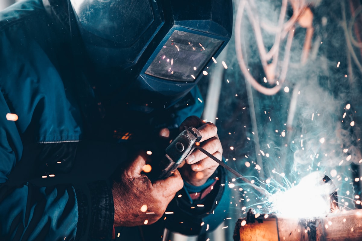Welder at work in an industrial workshop, golden light